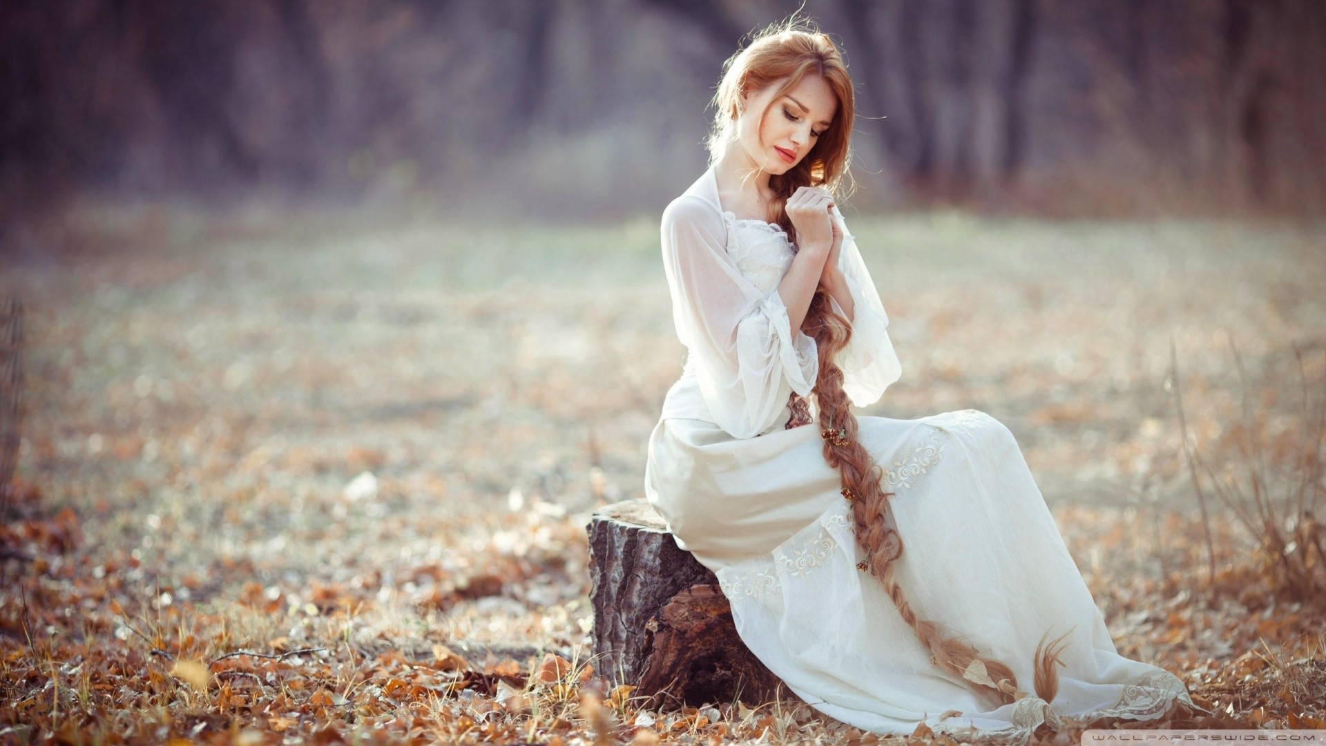 Free photo A girl in a white dress with a long braid.