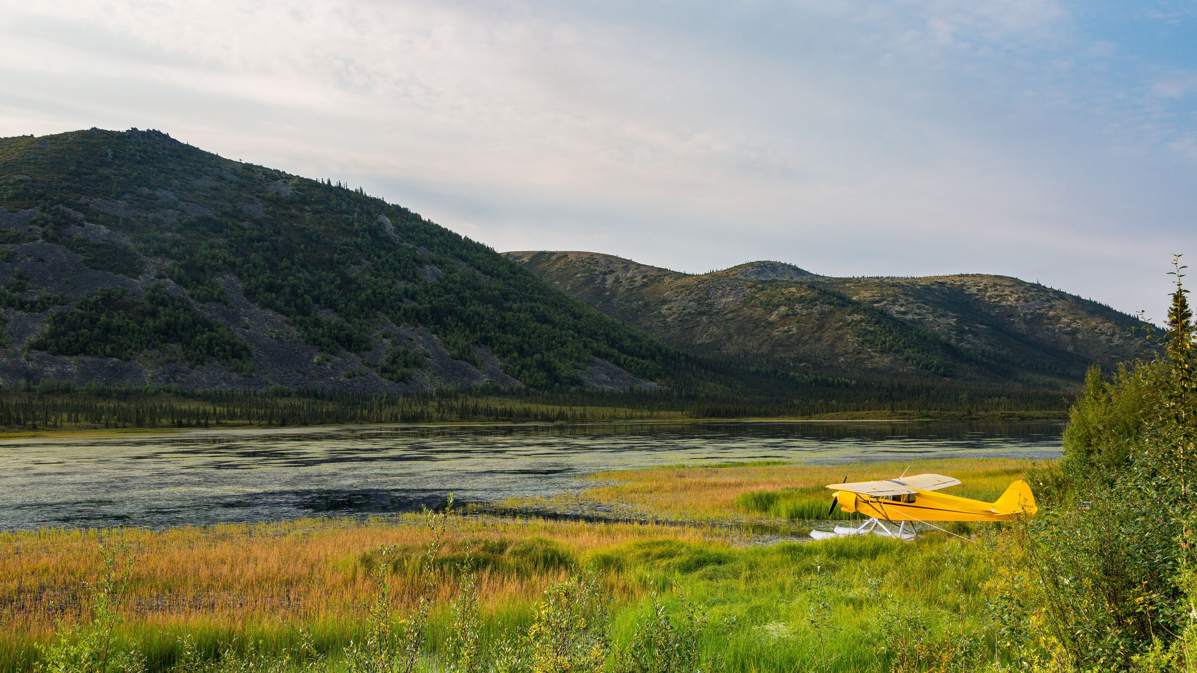 Free photo Yellow airplane parked on the riverbank