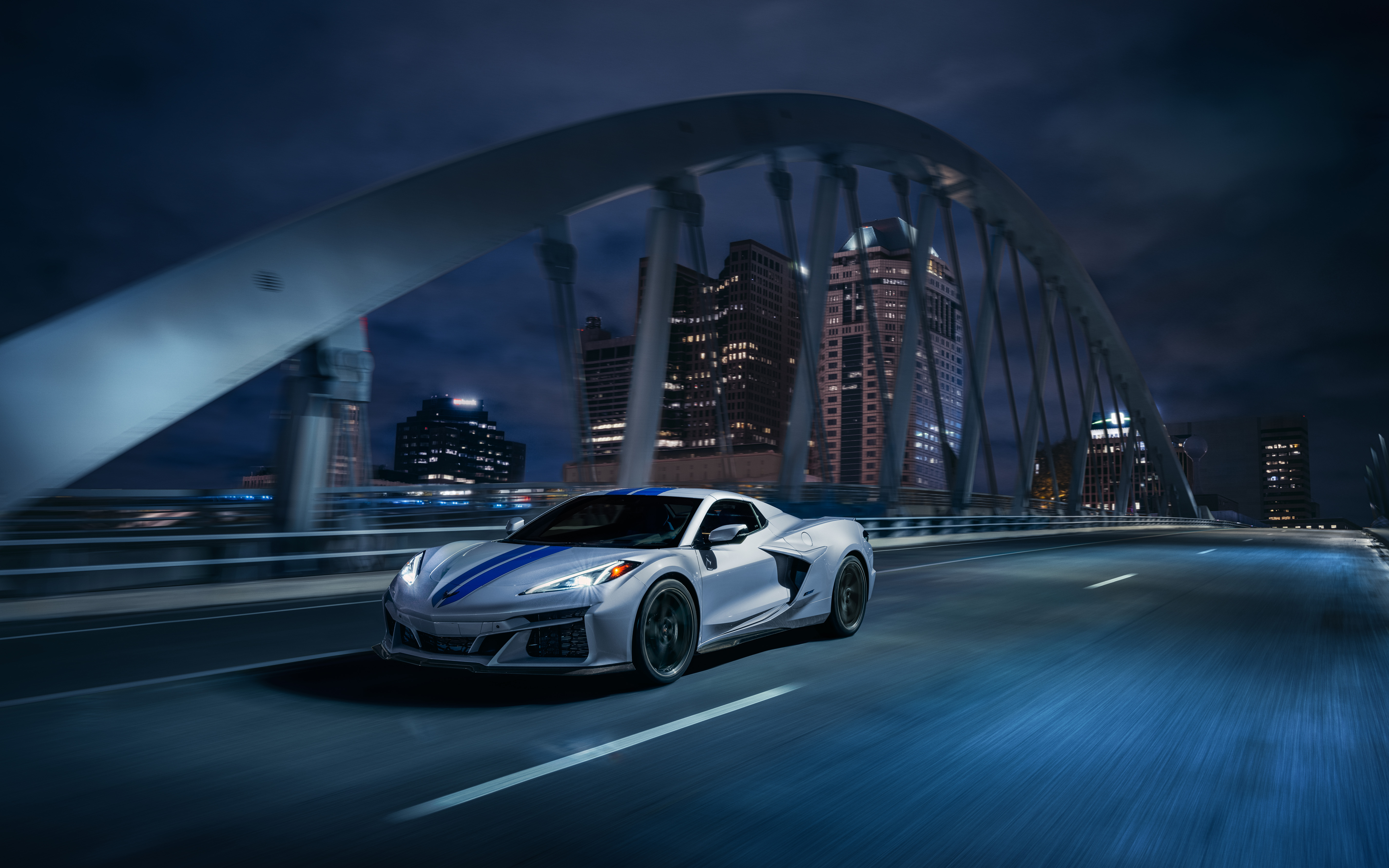 Free photo Chevrolet Corvette drives over the night bridge