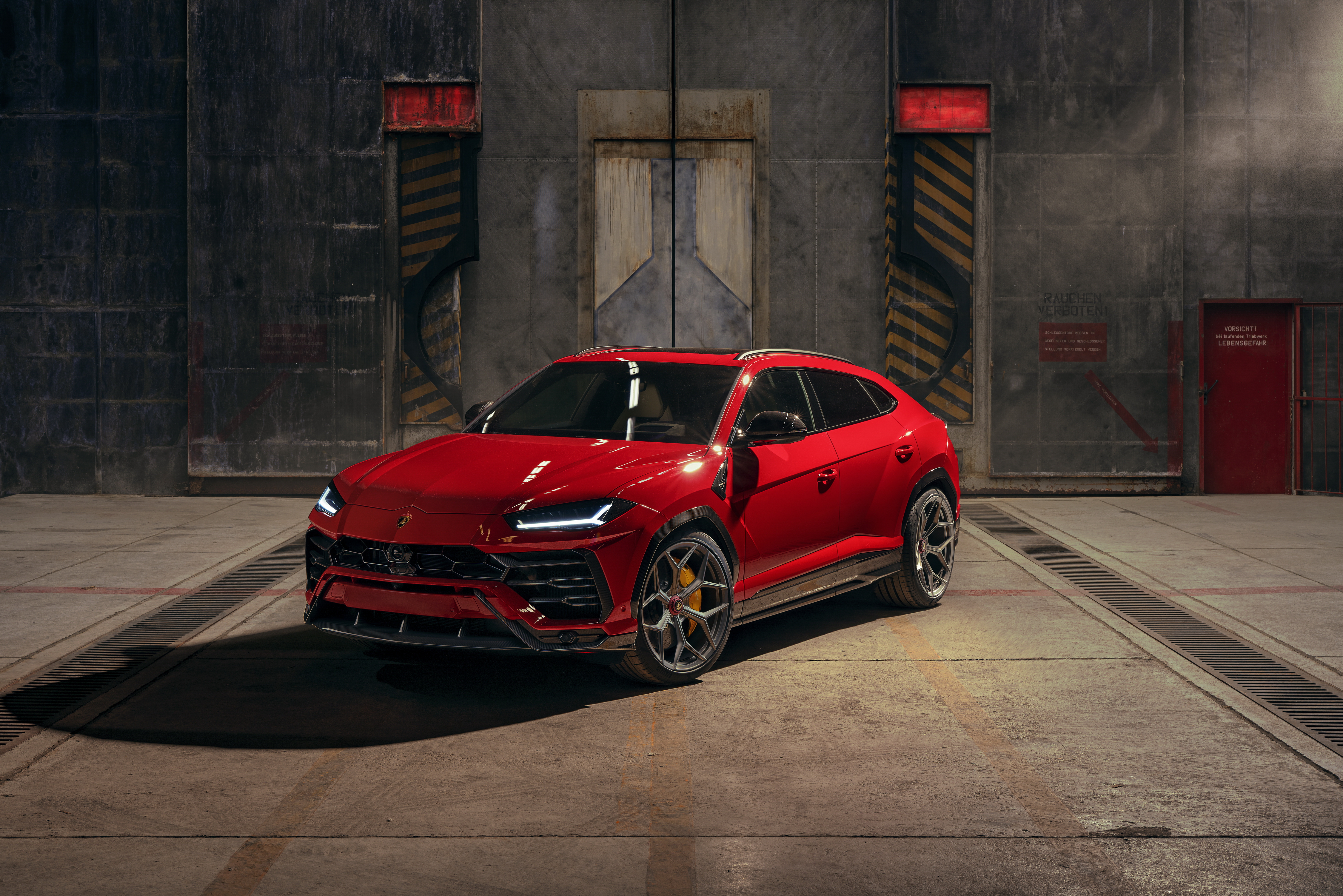 Free photo A red Lamborghini Urus stands at the big gate