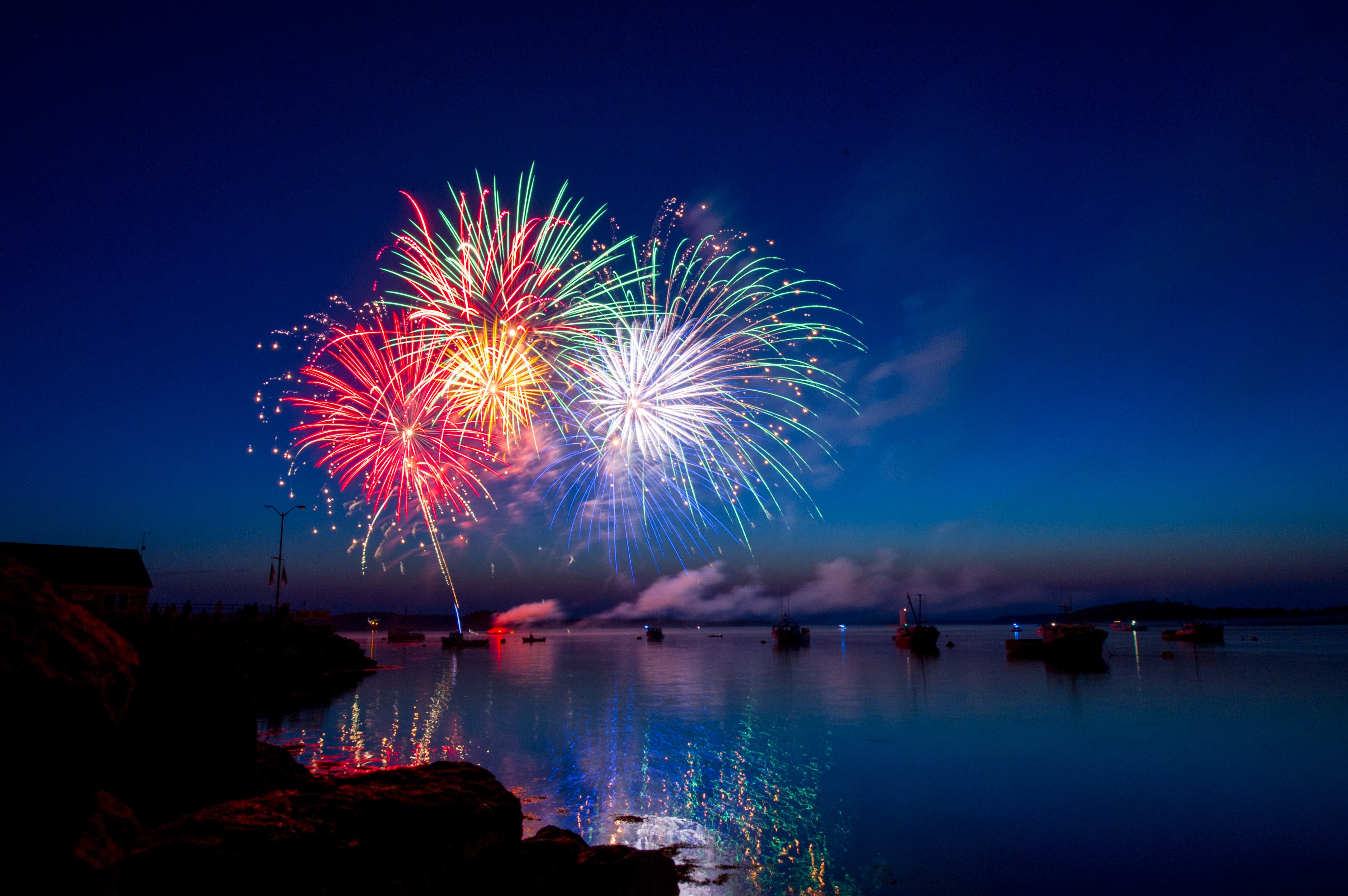 Free photo Night fireworks over the river with ships