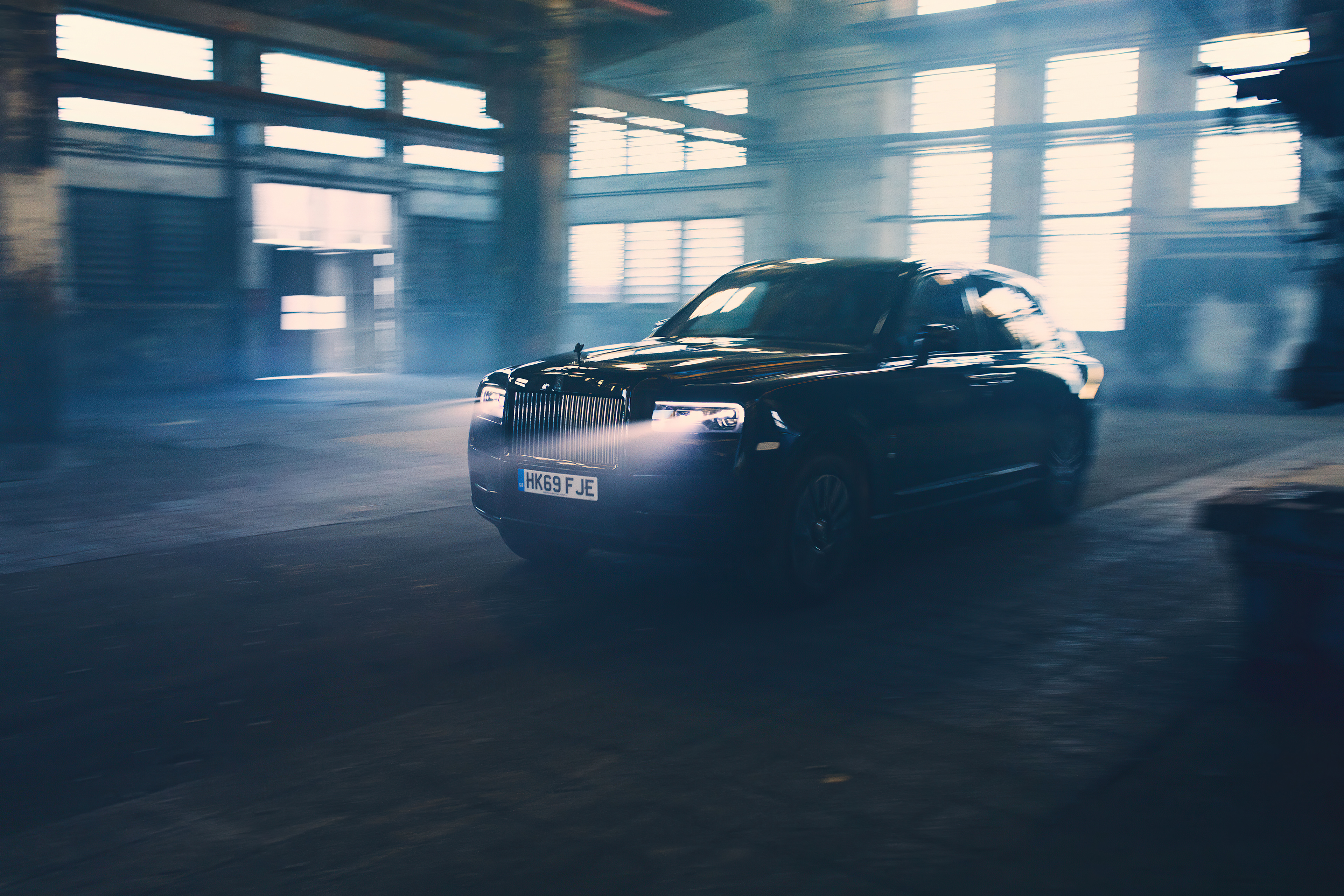 Free photo Black Rolls Royce Cullinan in a dusty garage