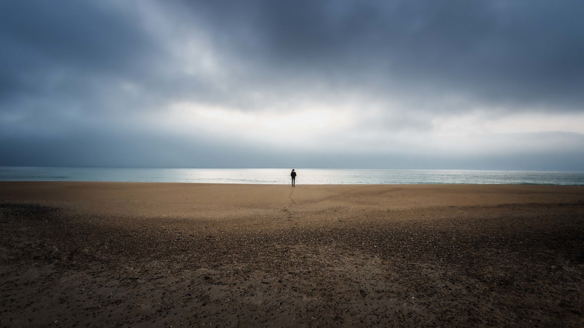 海边大沙滩上的孤独男子