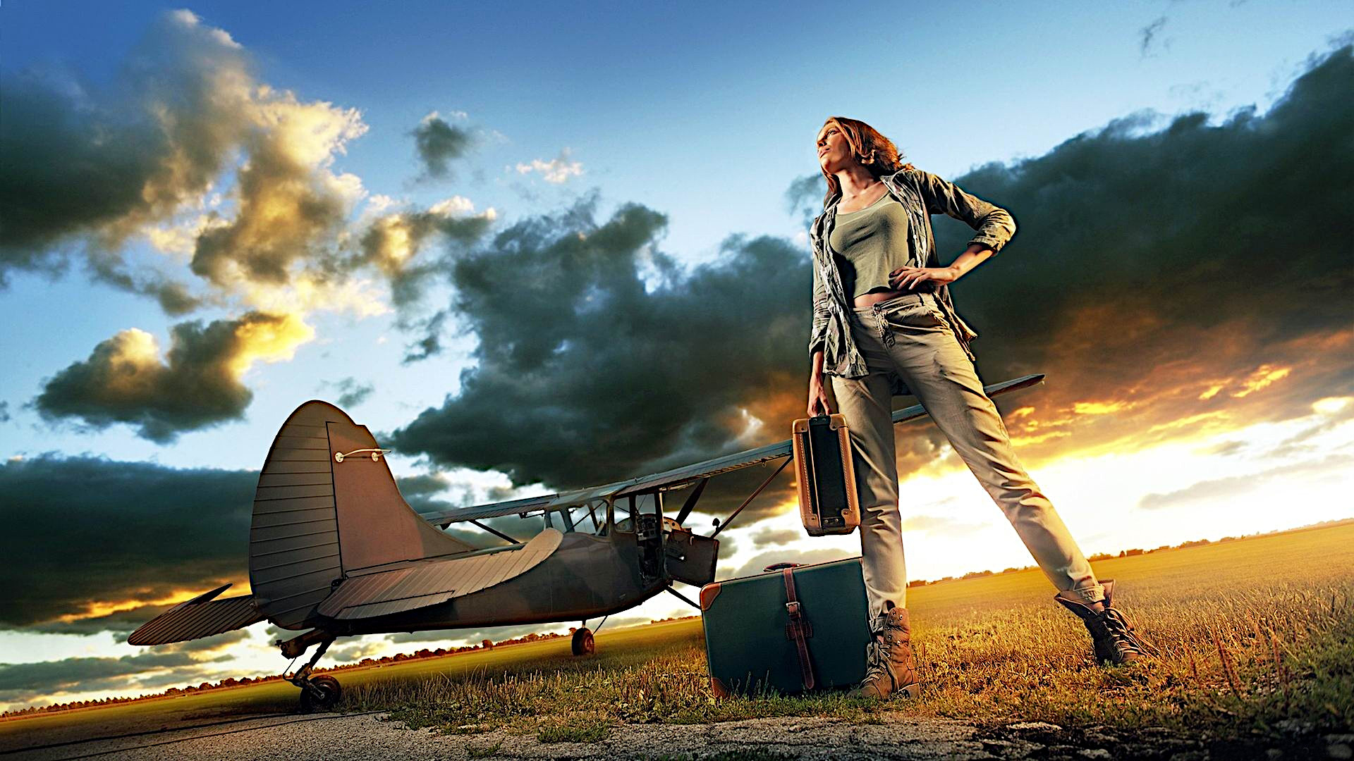 Free photo Girl with suitcases standing next to the plane at sunset