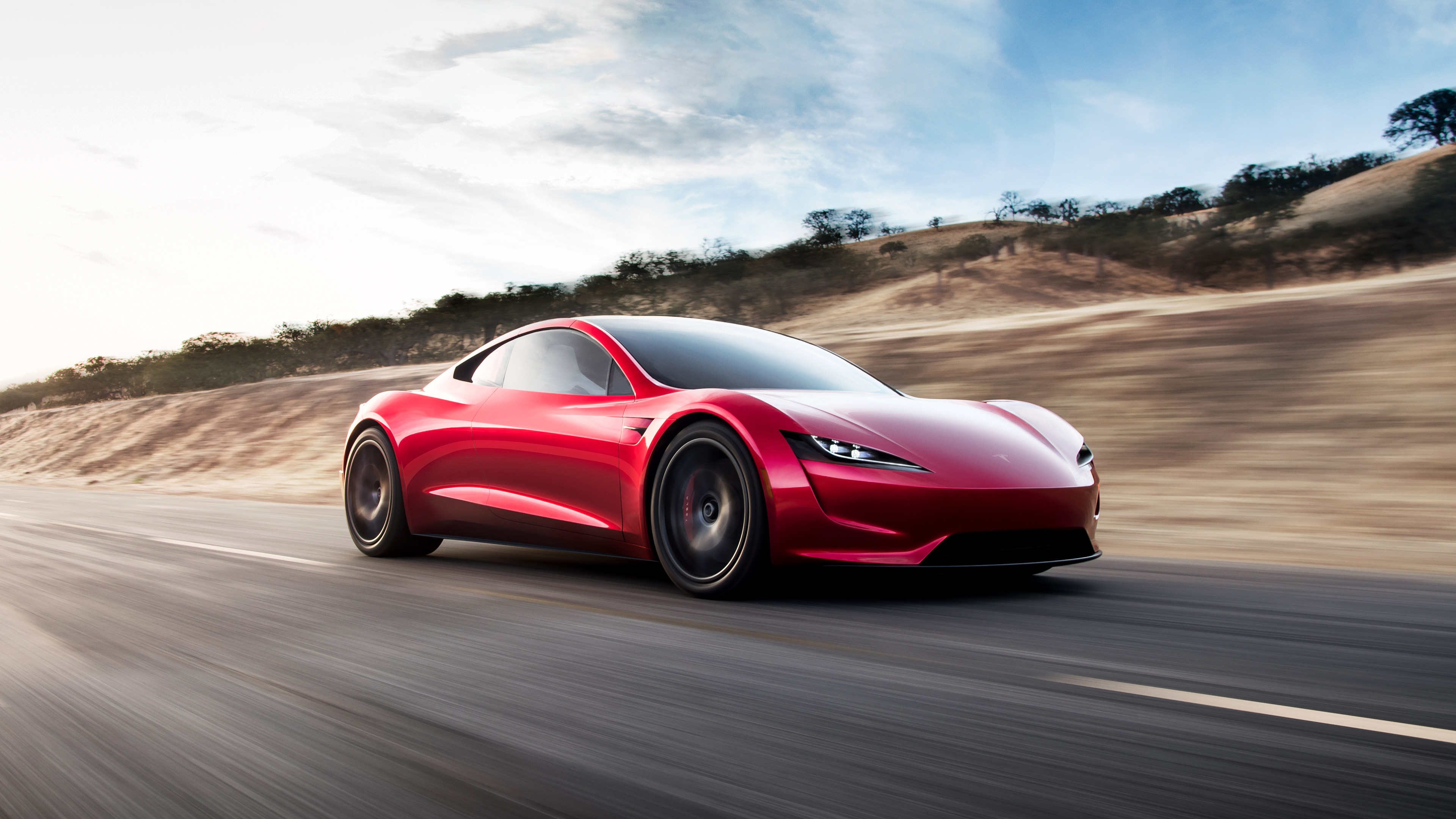 Free photo Red Tesla roadster goes down the road at high speed