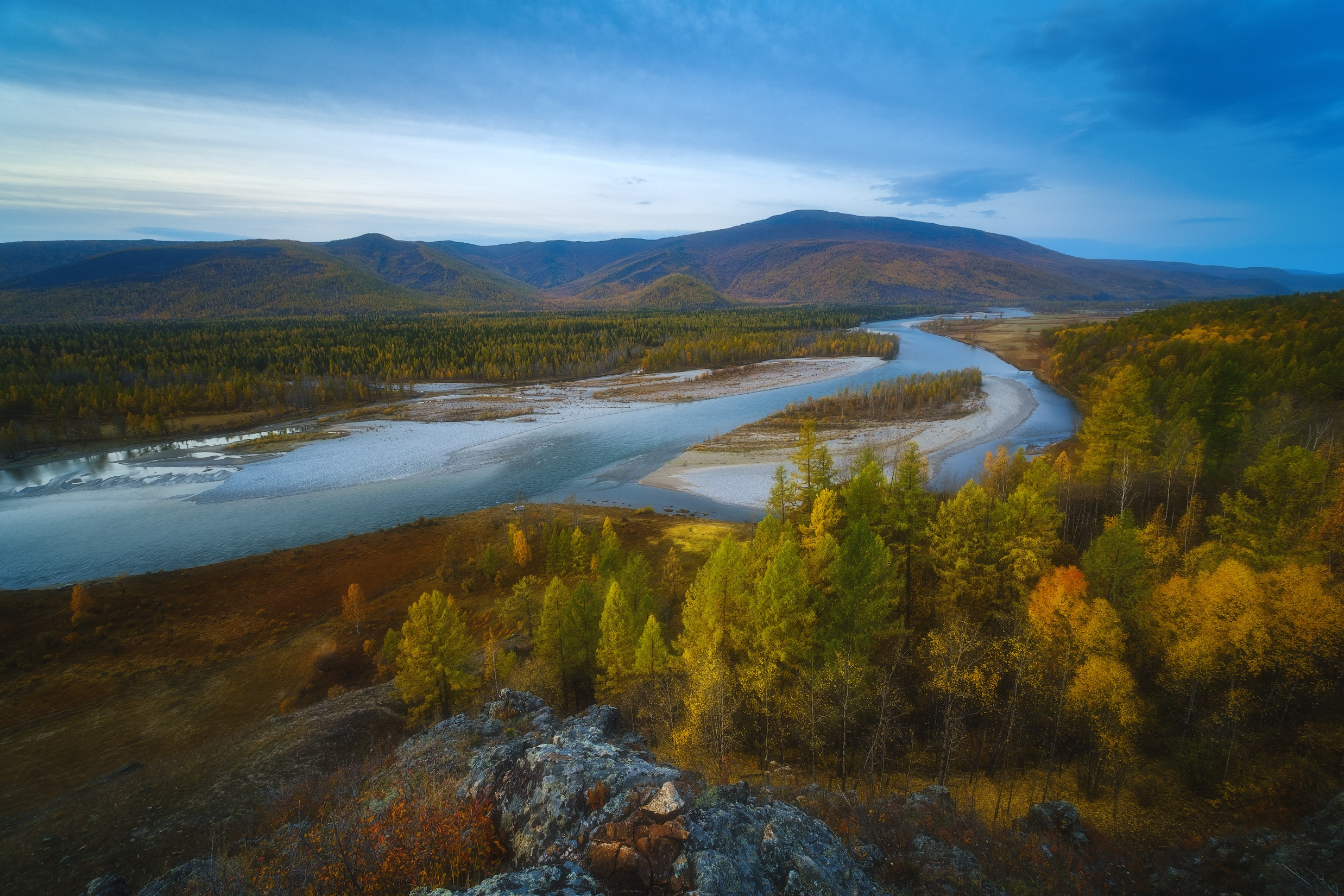 Free photo An autumn day by the river in a valley with hills and woodland