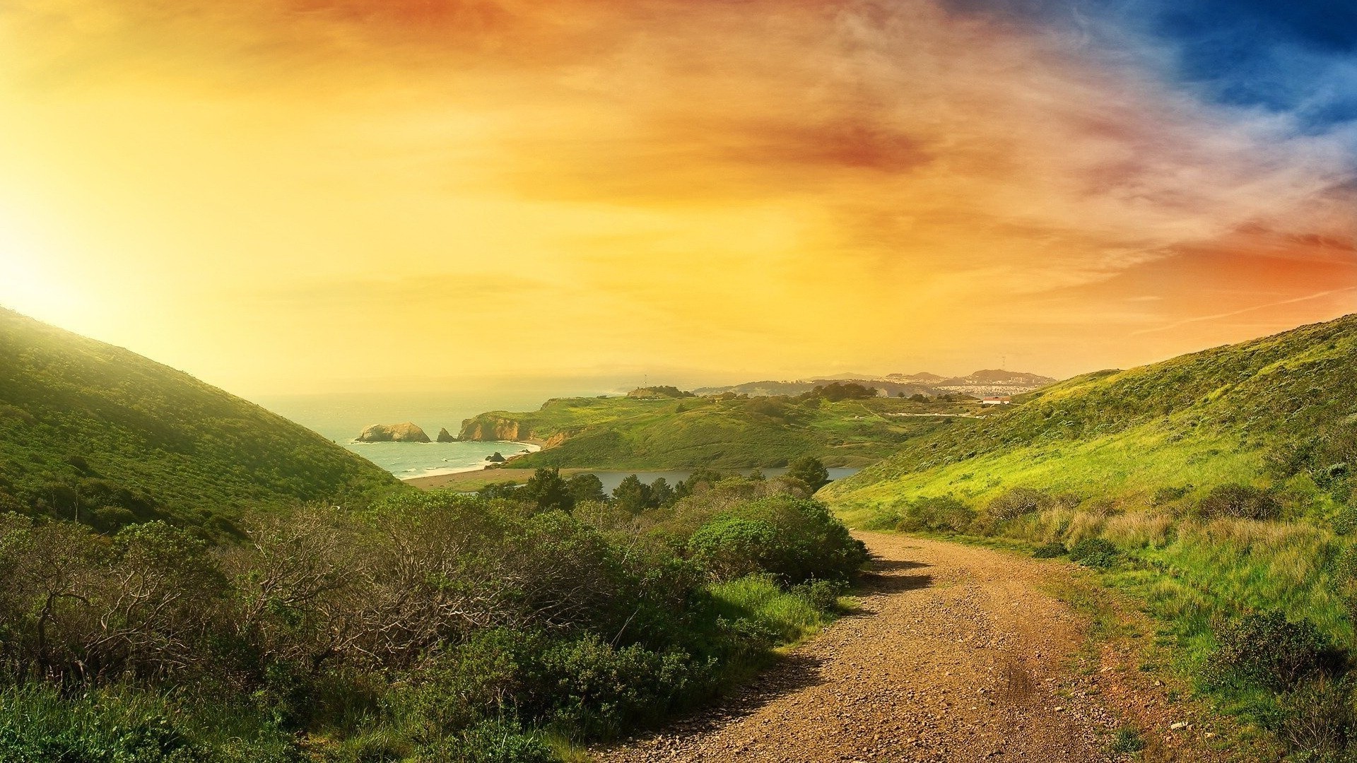 Free photo Landscape with road, hills and a bright sunset sky.