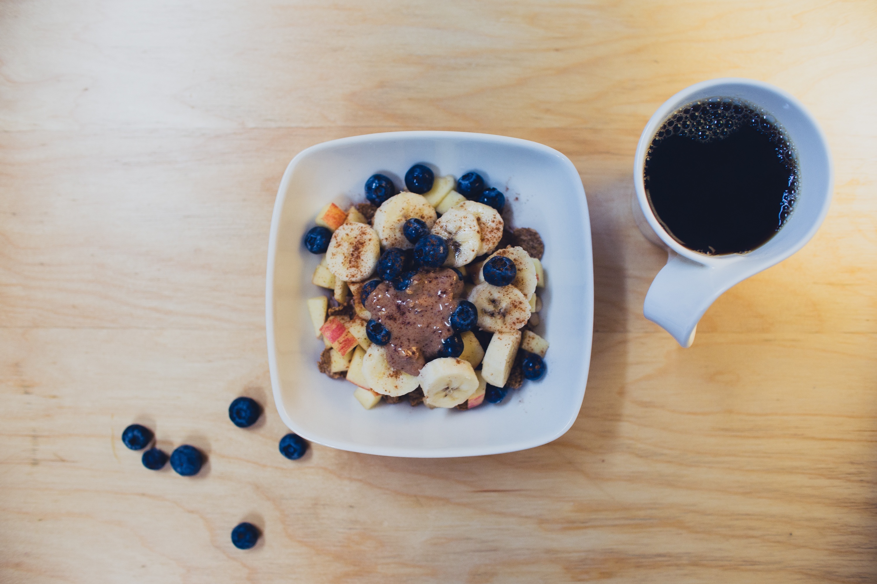 Morning set: coffee and fresh fruits on a wooden table.