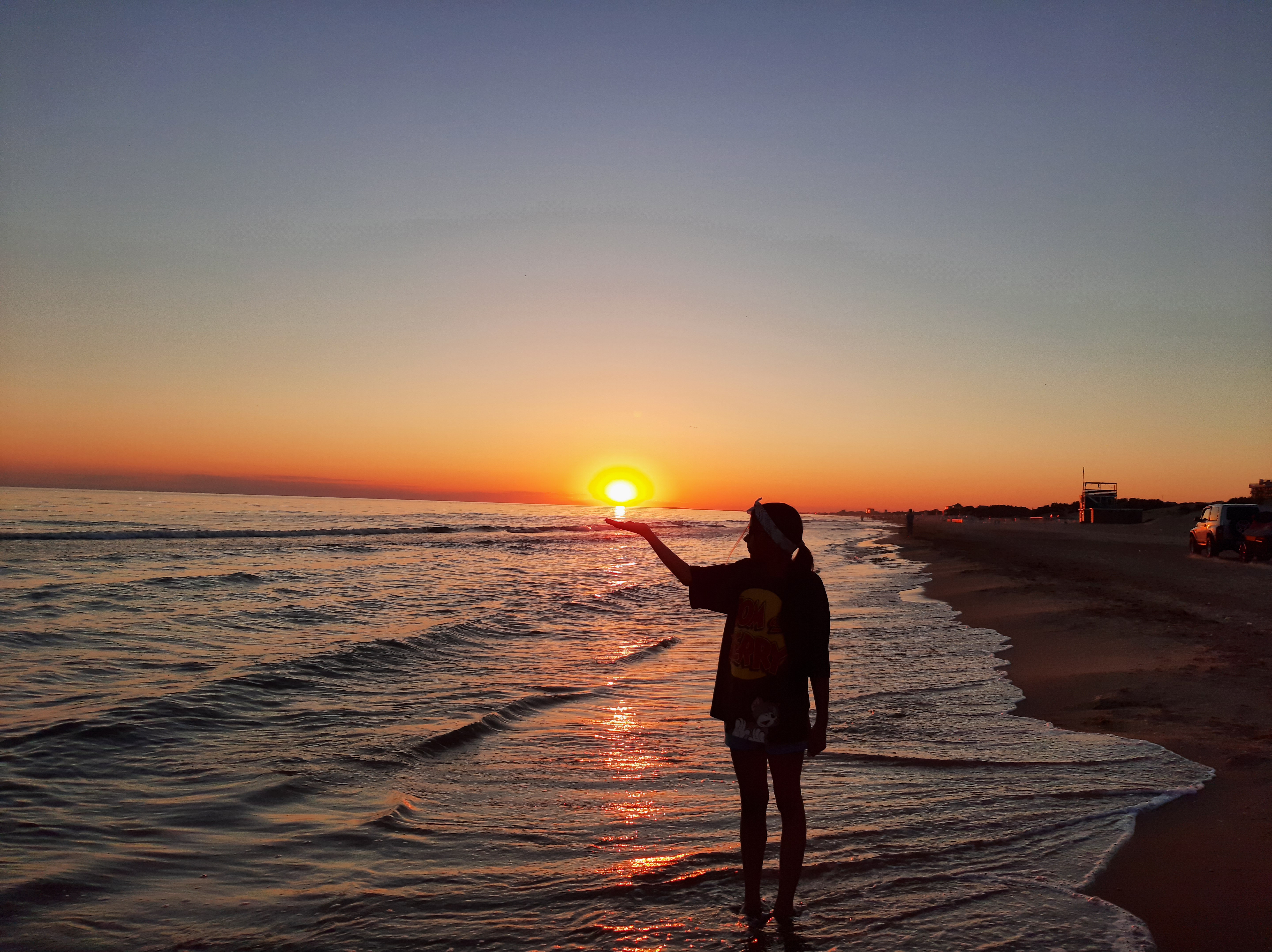 Free photo A girl holding the sun at sunset