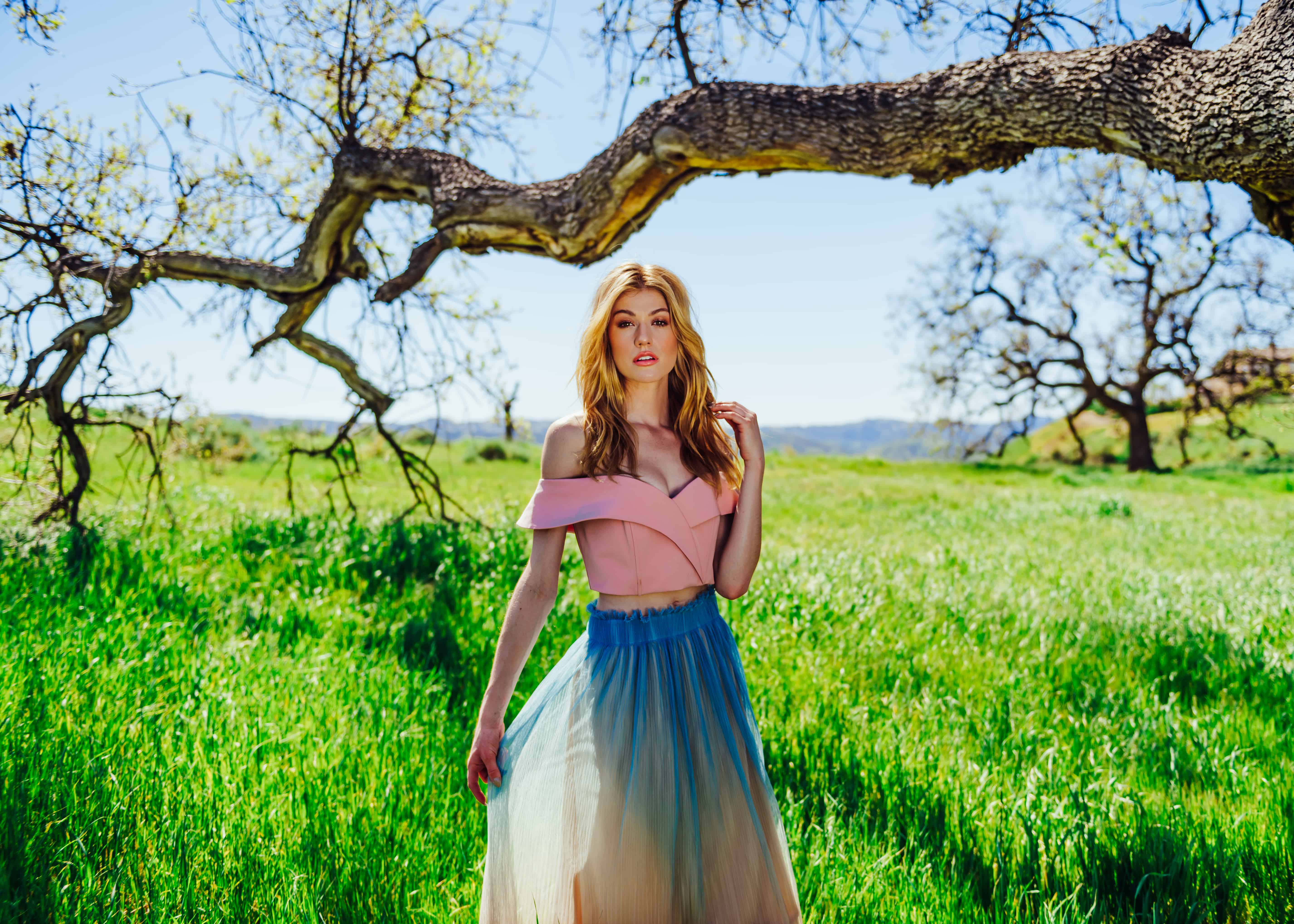 A girl in a light skirt against a green field