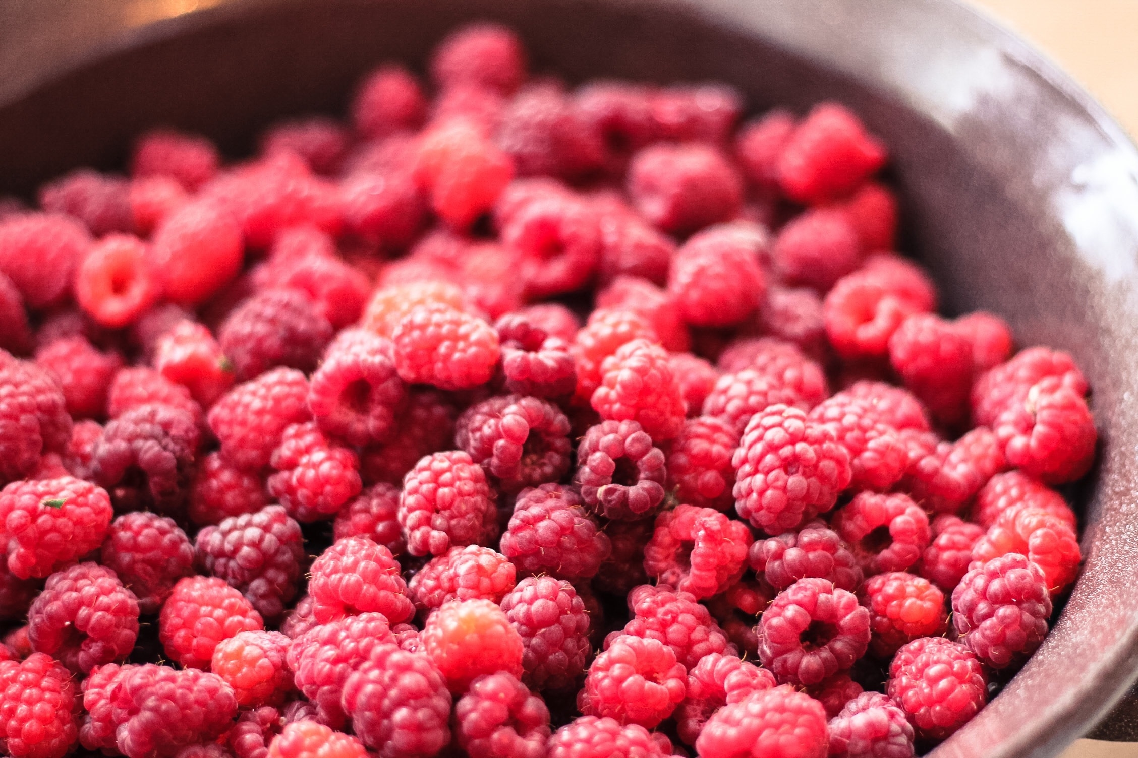 Free photo Ripe raspberries in an earthenware pot