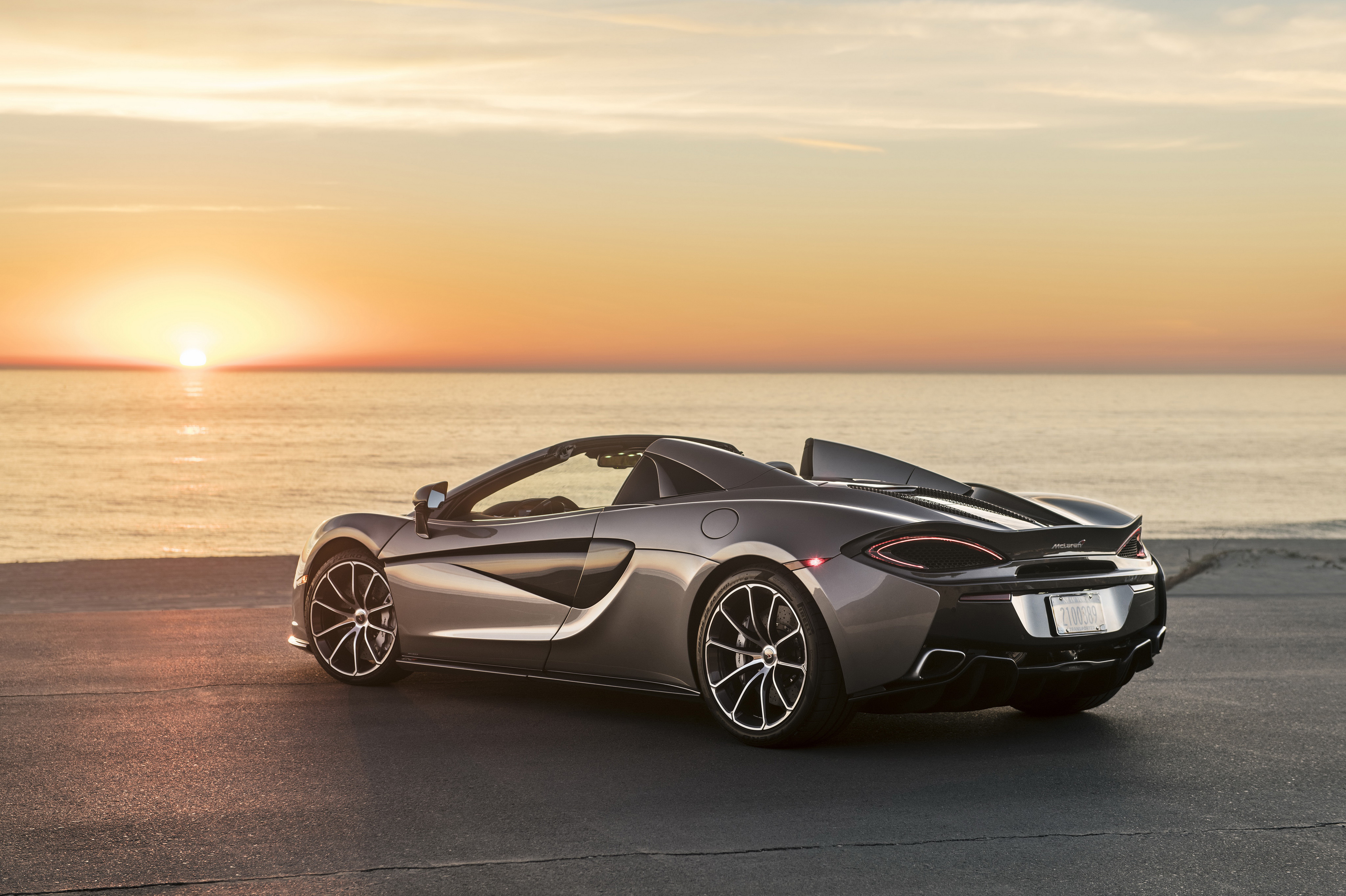 Бесплатное фото Кабриолет Mclaren 570S Spider на берегу моря при закате дня