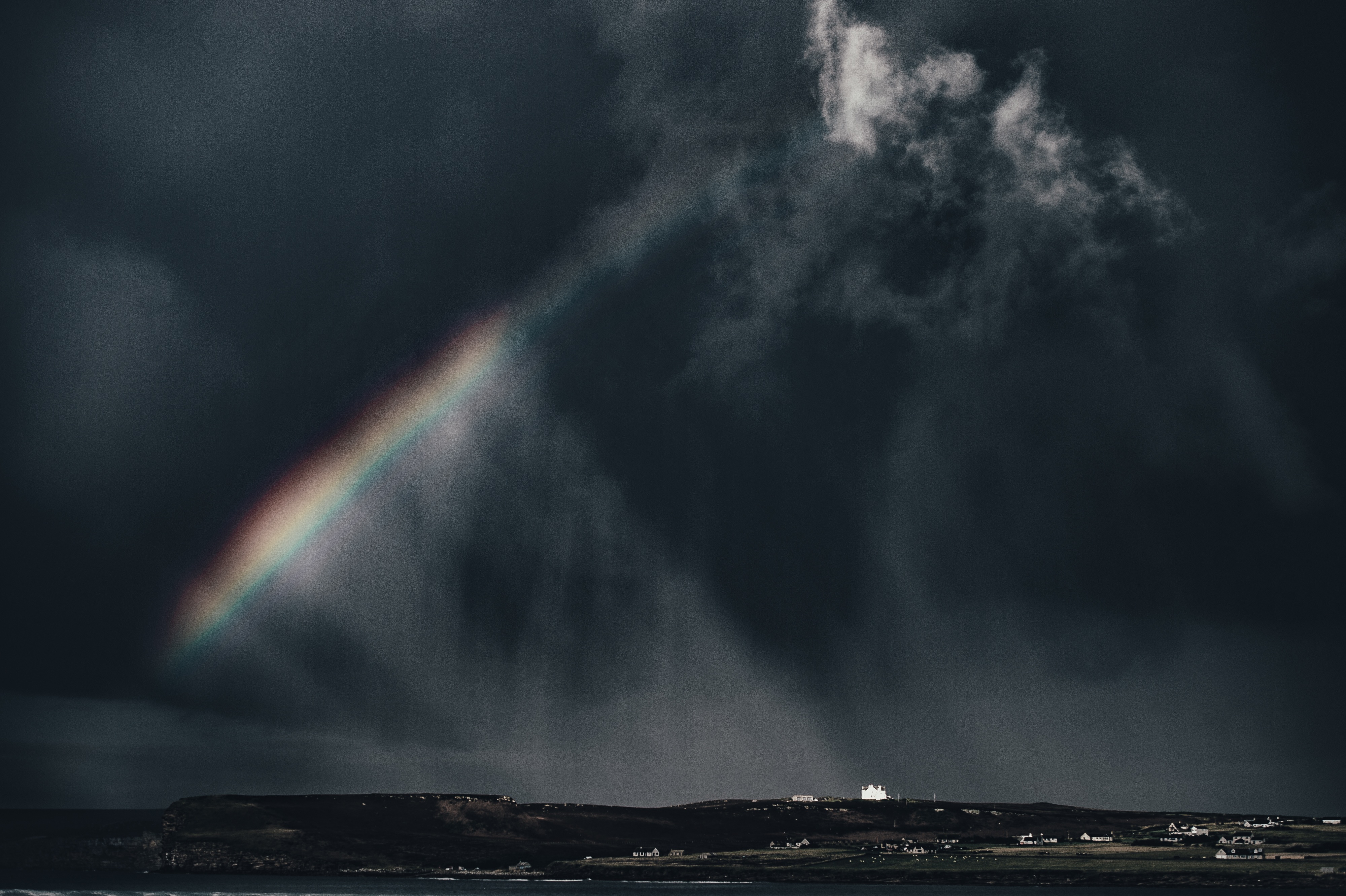 A rainbow in a dark sky during a storm
