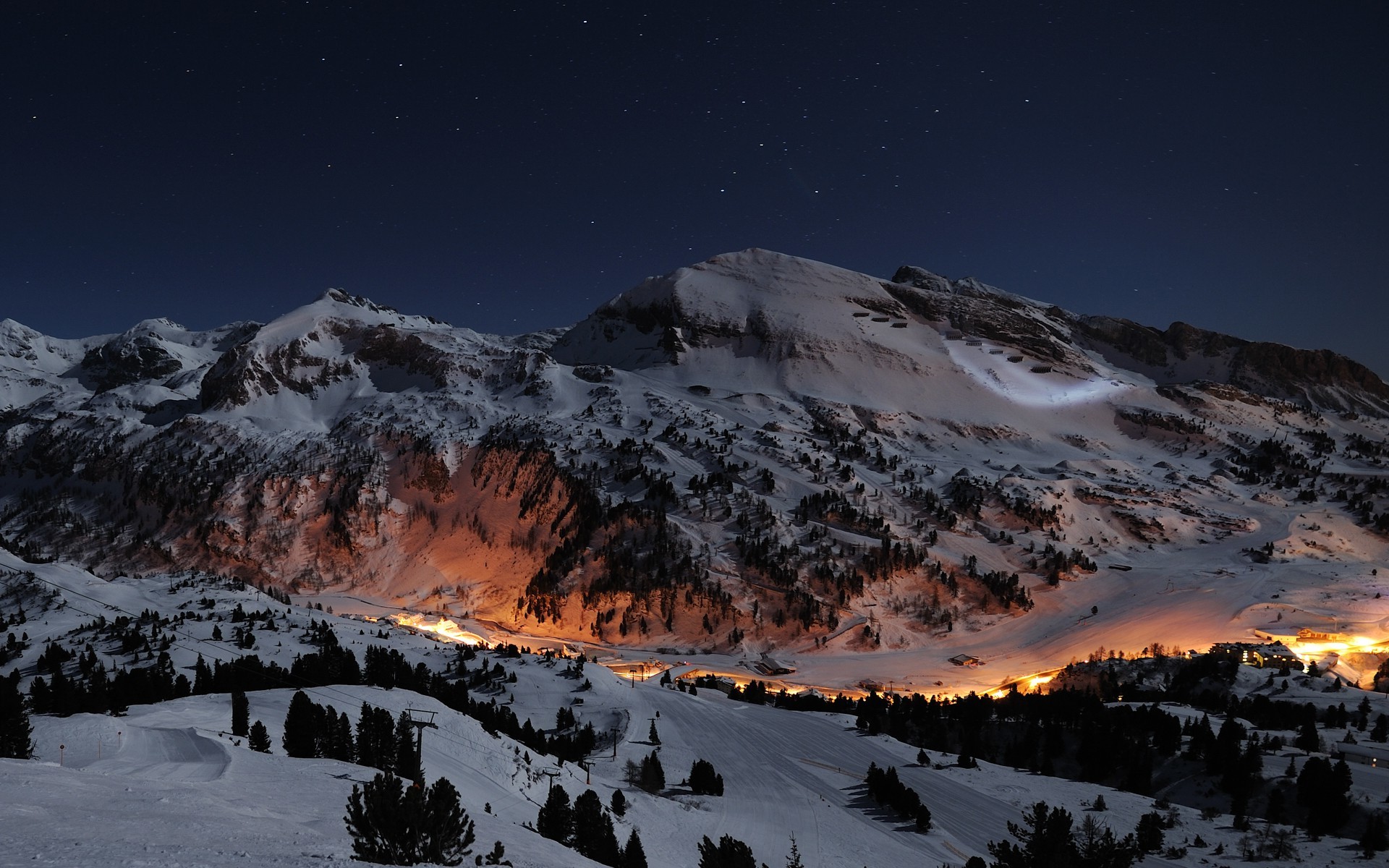 Free photo A picture of the settlement amidst the snowy night mountains