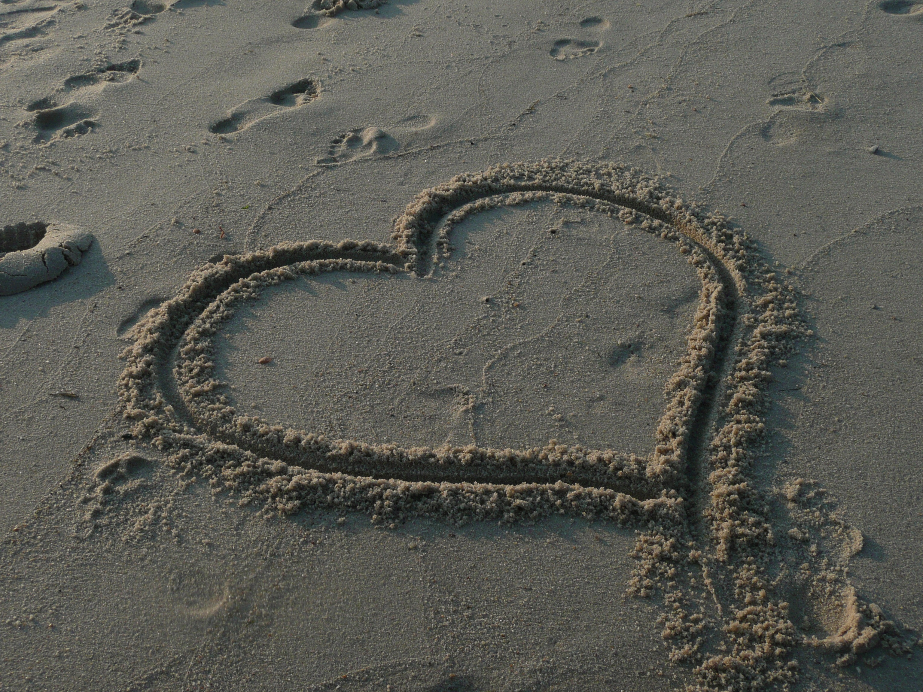 Free photo A heart on the sandy shore of the beach