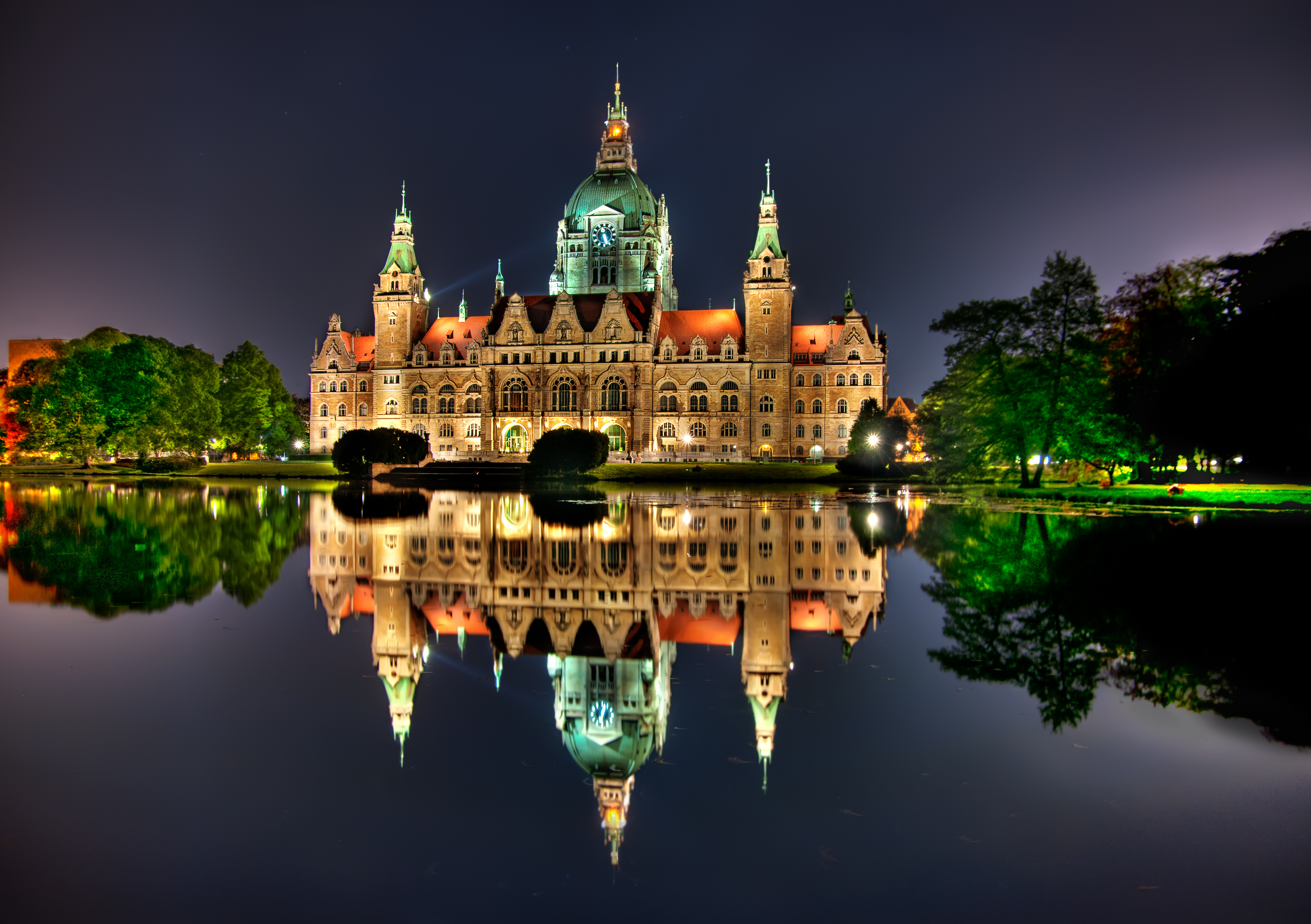 Бесплатное фото Светящееся здание отражается в озере в вечернее время