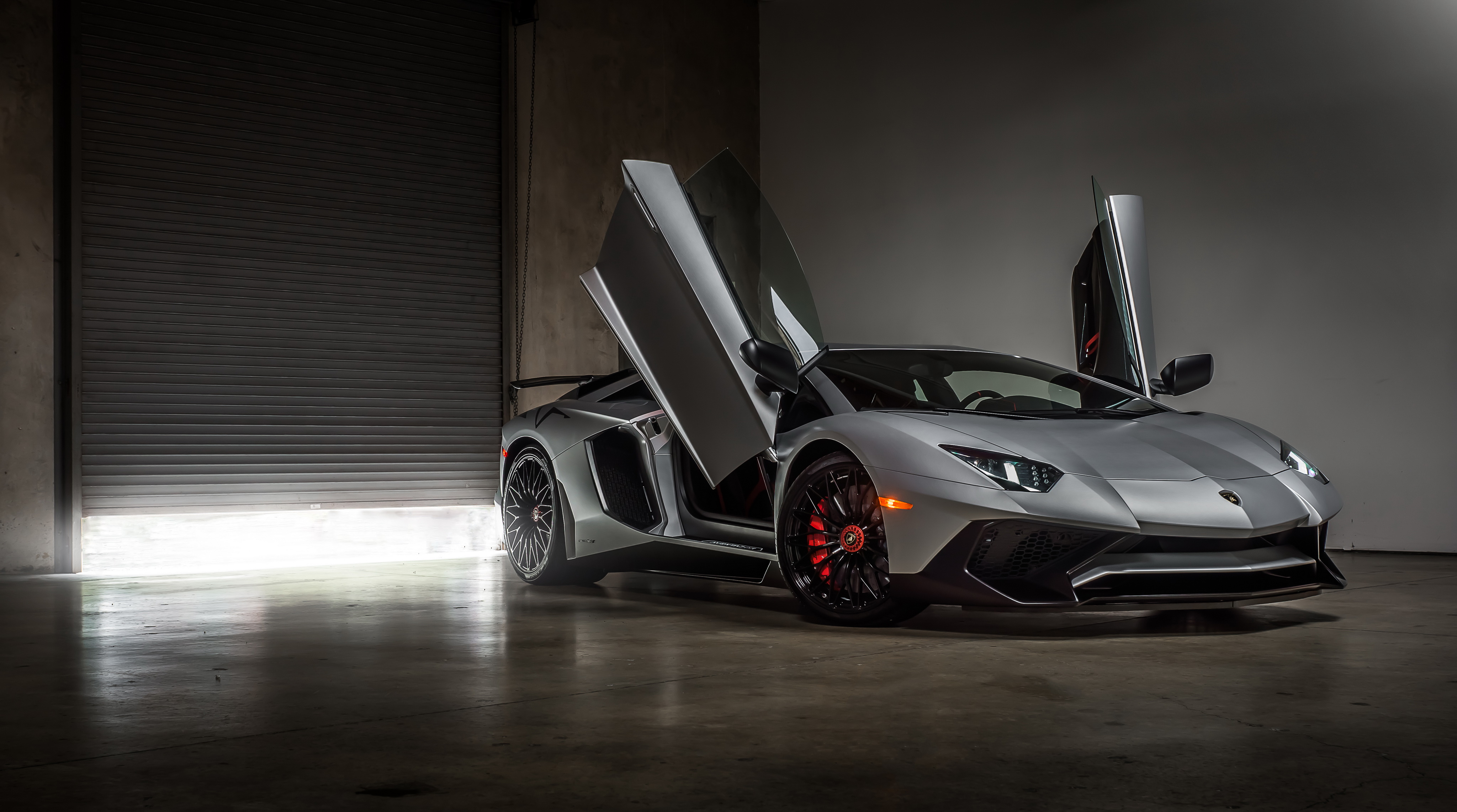 Free photo A gray Lamborghini Aventador with the doors open.