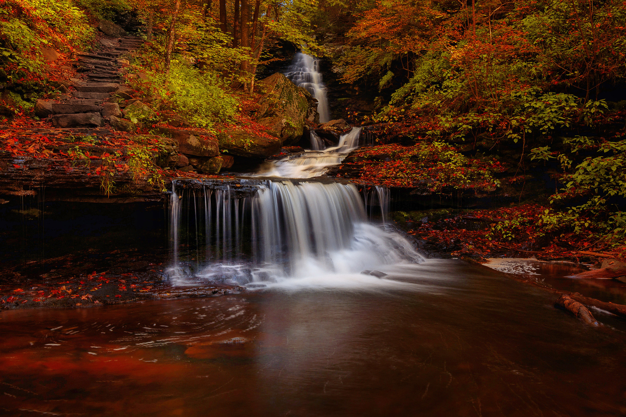 秋天的瀑布在一个五彩缤纷的森林里
