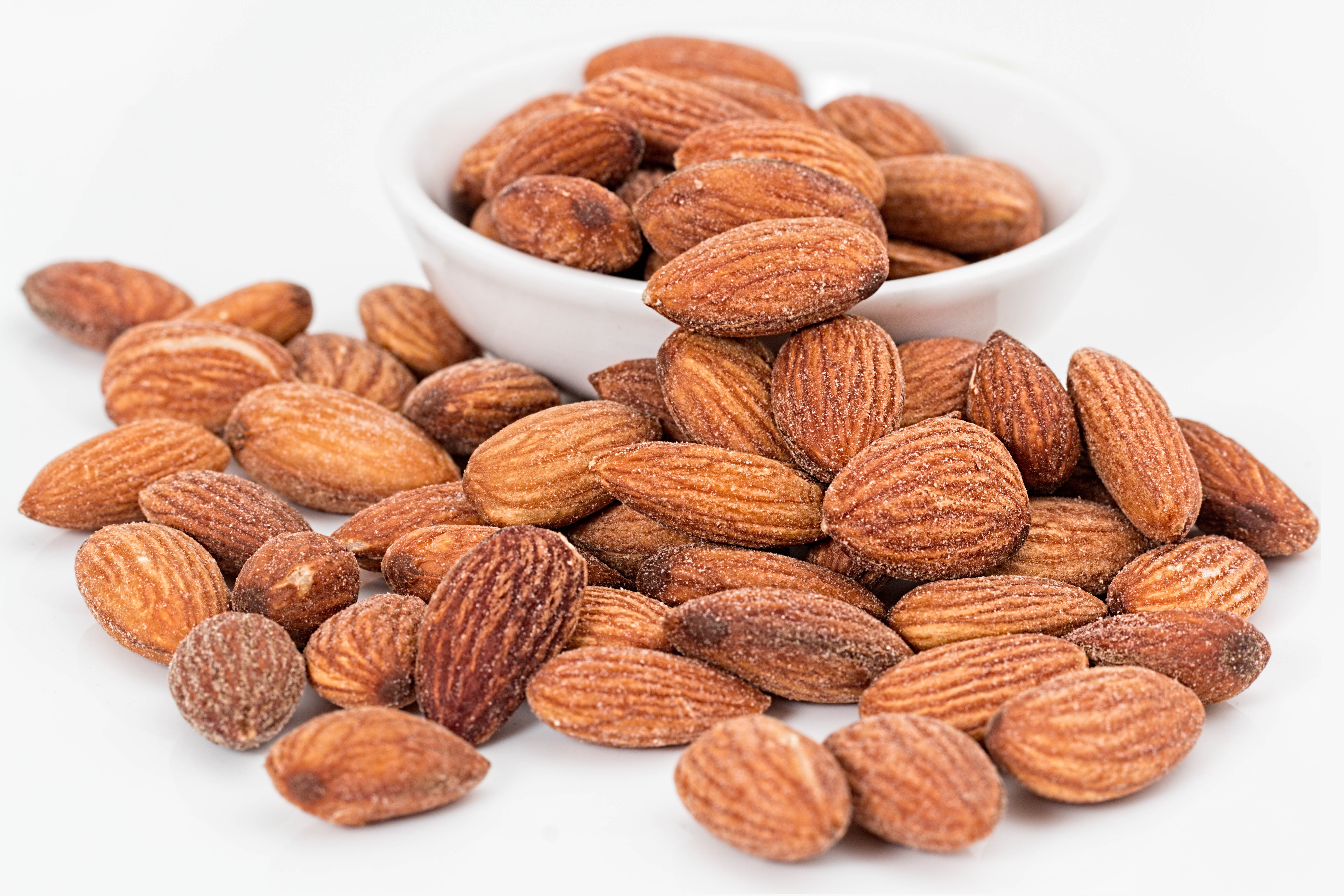 Free photo Scattered almond nuts on a white background